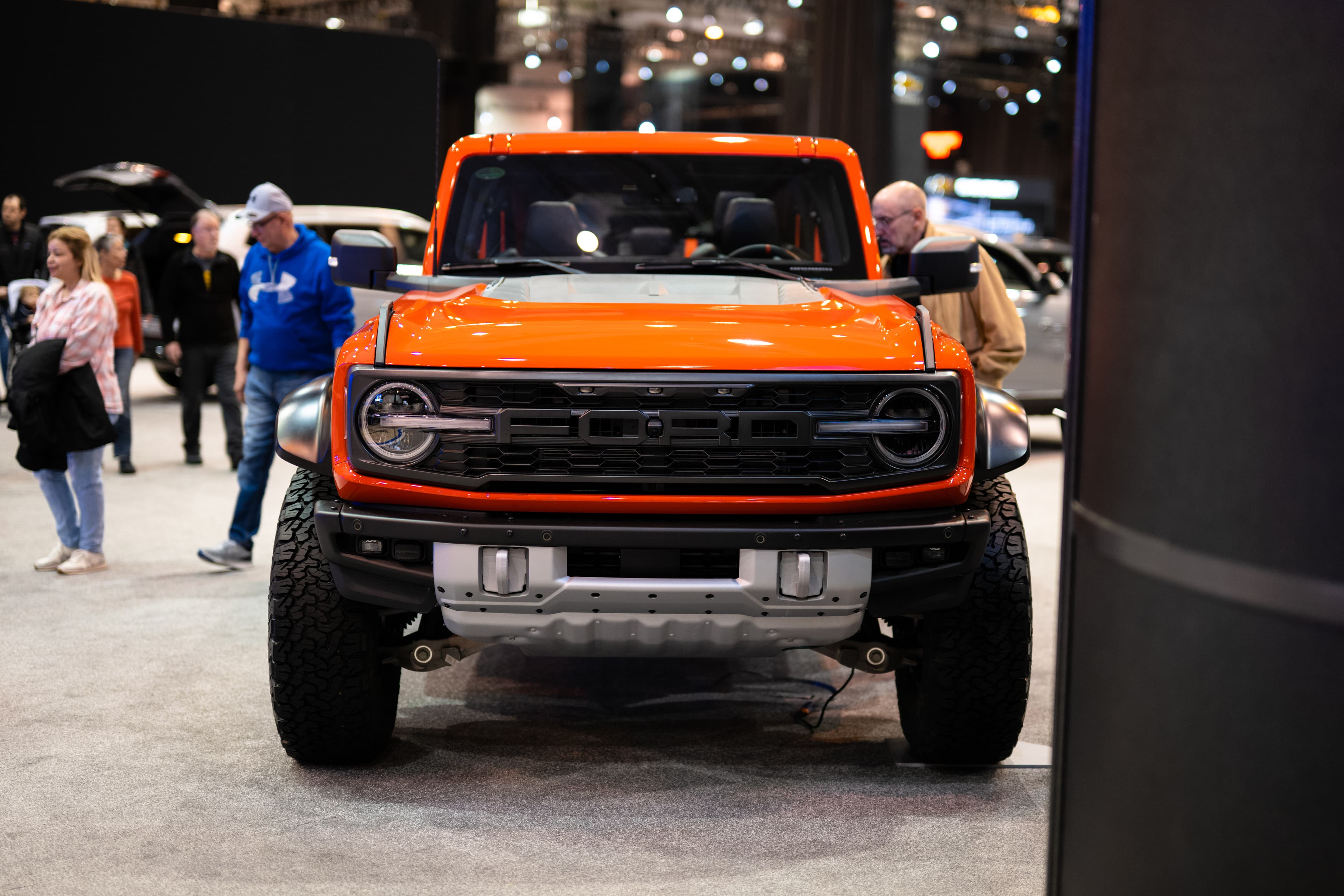 Code Orange Bronco Raptor with the roof panels off at the 2023 Cleveland Auto Show, shot head-on
