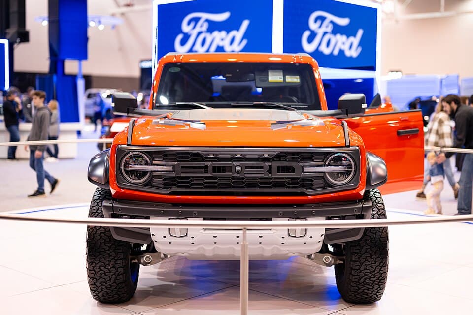 Code Orange Bronco Raptor head-on at the 2024 Cleveland Auto Show, showing the tubular front bumper and the full-width grille.