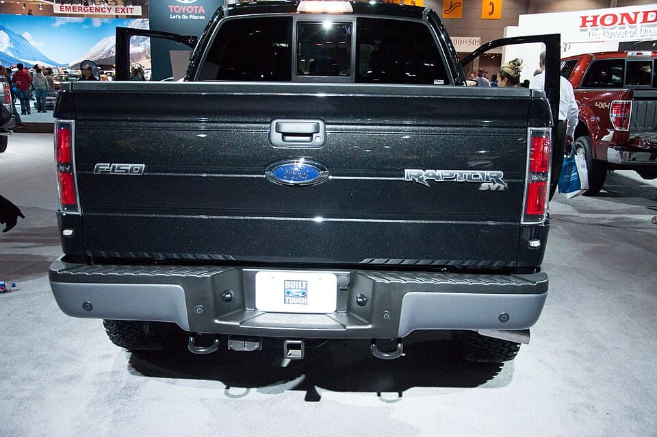 2014 SVT Raptor photographed straight-on from the rear at the Chicago Auto Show — tailgate RAPTOR SVT lettering and the dual exhaust exit.