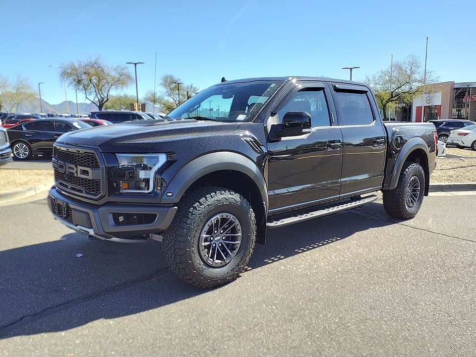 Black 2020 Raptor SuperCrew on a dealer lot in Scottsdale, Arizona, front three-quarter in hard desert sunlight.