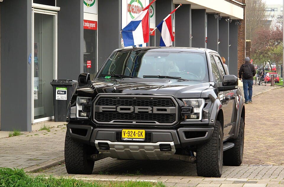 Dark 2017 Raptor SuperCrew parked kerbside in Leiden, Netherlands, shot head-on — the grille and bumper fill the frame.