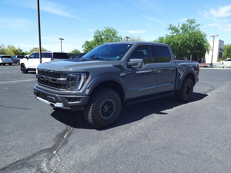 2021 Raptor SuperCrew on a dealer lot in Scottsdale, Arizona, front three-quarter — factory wheels and the standard 35-inch tyre package.