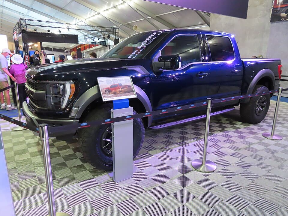 Blue 2021 Raptor on the block at Barrett-Jackson Scottsdale 2021, front three-quarter under auction-hall lighting.