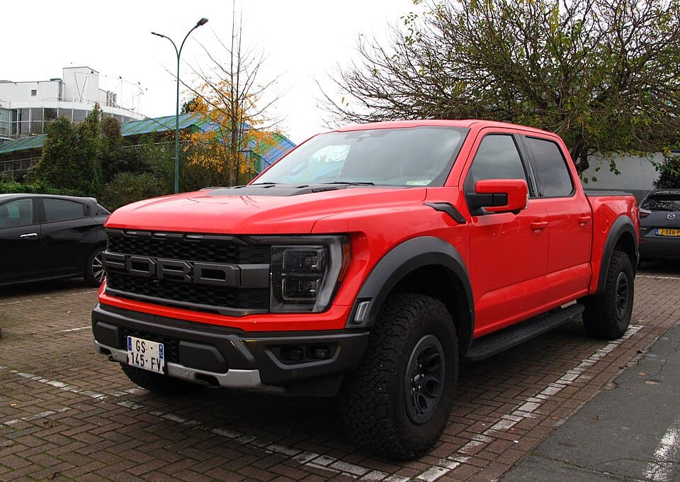 Red 2022 Raptor with the 3.5-litre EcoBoost V6, front three-quarter parked on a European street.