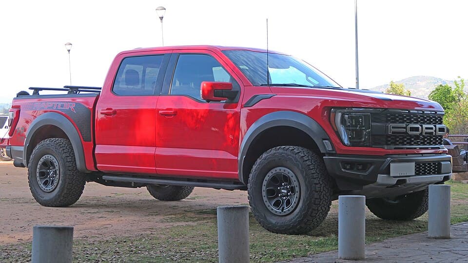 Red 2022 Raptor SuperCrew parked kerbside in Chile, front three-quarter, on factory wheels.