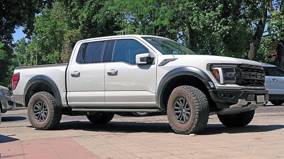 White third-gen Raptor SuperCrew, clean side profile on a paved lot — good reference for the bed length and wheelbase.